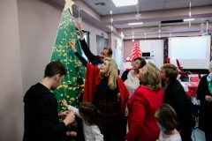 Οι κυρίες Βαρδινογιάννη και Παυλοπούλου τοποθετούν στολίδια που έφτιαξαν τα παιδιά στο χριστουγεννιάτικο δέντρο